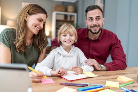 Family parents and child doing homework and learning together at home